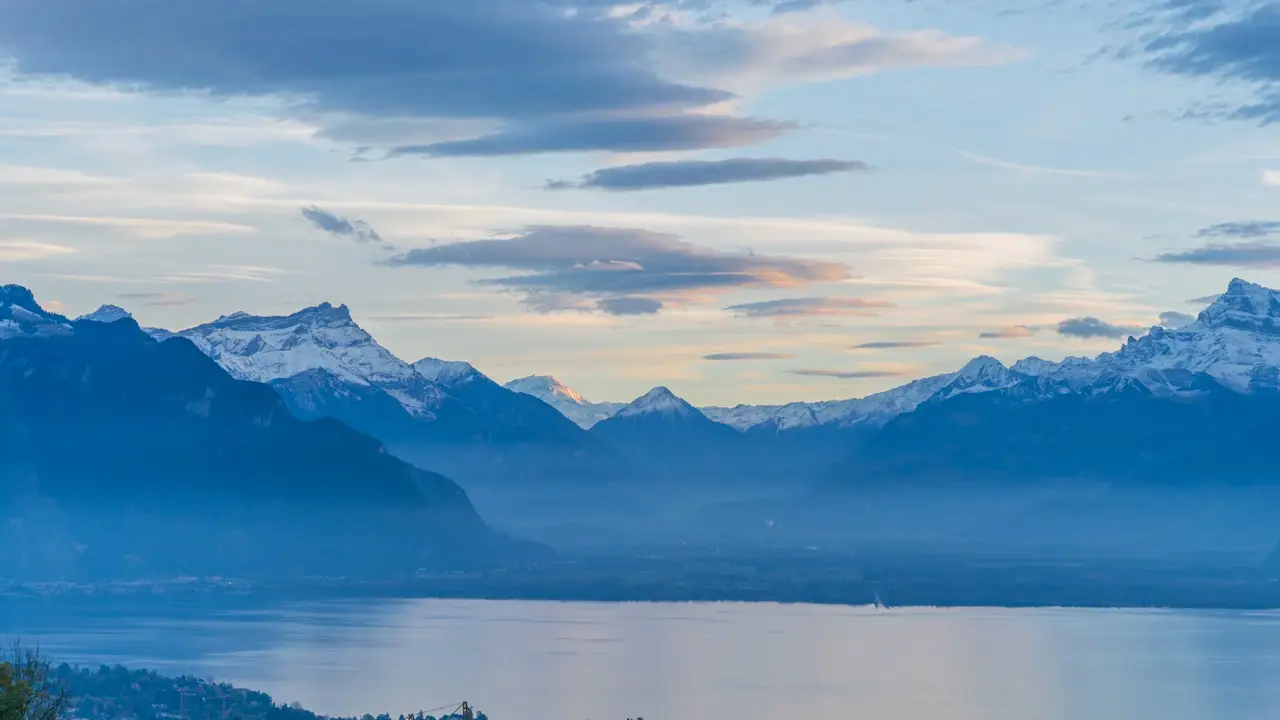 paysage hivernal dans le massif du Mont-Blanc, avec vue sur la chaîne des Aravis au-dessus des nuages et des villages.